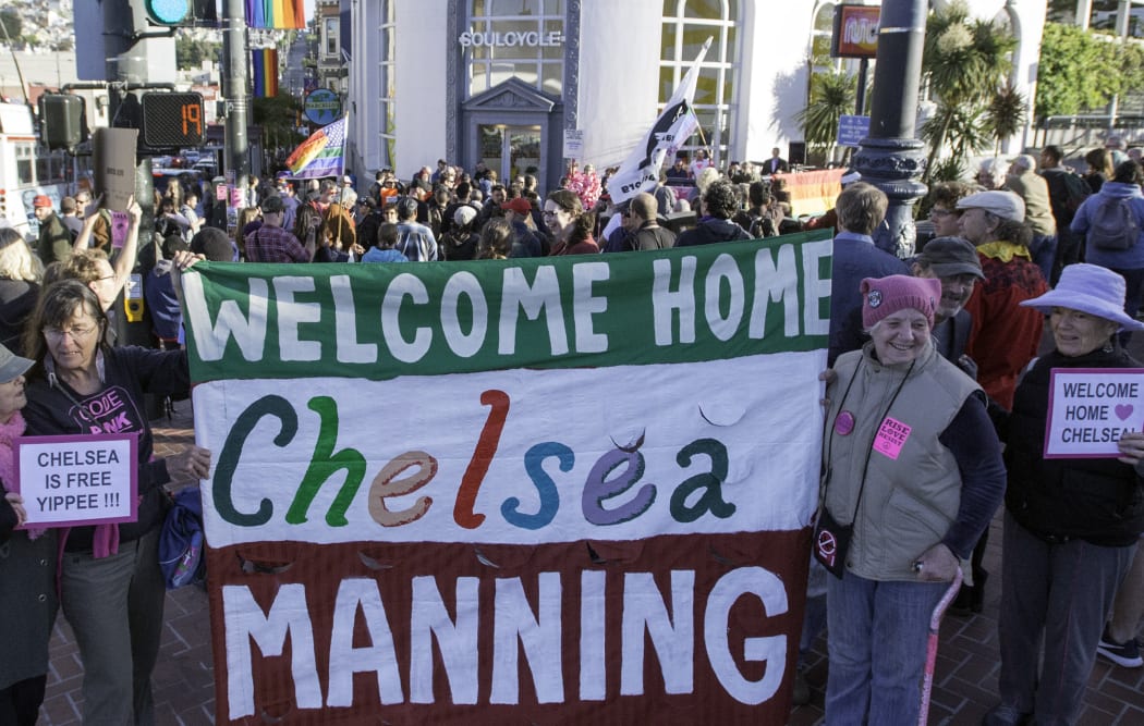 People cheer and hold up signs showing support for Chelsea Manning in the Castro District of San Francisco, California in 2017, during a celebration for her release.