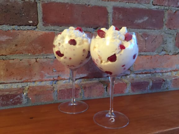 Two wine glasses containing an Eton mess dessert.