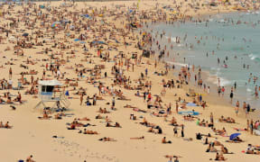 Sunbathers are seen on Bondi Beach as temperatures soar in Sydney on December 21, 2019. - Australia this week experienced its hottest day on record and the heatwave is expected to worsen, exacerbating an already unprecedented bushfire season, authorities said. (Photo by FAROOQ KHAN / AFP)