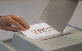 A voter casts his ballot papers for the German federal elections at a polling station in Gutach near Freiburg in the Black Forest region, southern Germany