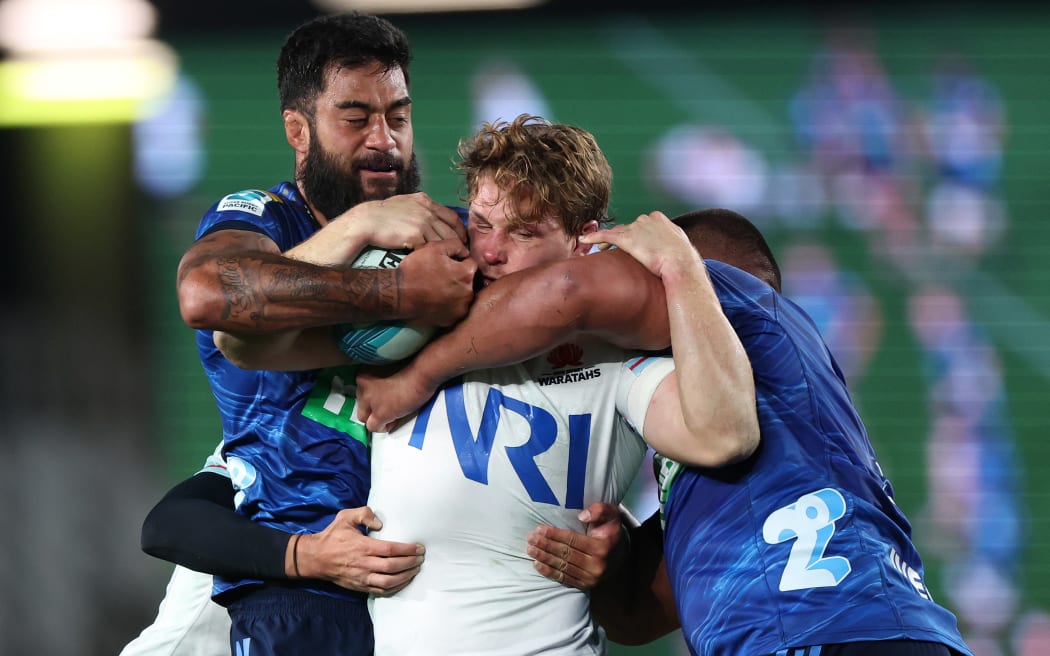 Michael Hooper of the Waratahs is wrapped up by Blues players during Super Rugby Pacific 2023.
