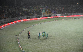 Ground staff leave after covering the pitch from a hailstorm shower that stopped the game during the fourth Twenty20 international cricket match between Pakistan and New Zealand at the Rawalpindi Cricket Stadium, 2023.