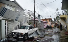 Residents of San Juan, Puerto Rico, deal with damages to their homes on September 20, 2017, as Hurricane Maria batters the island.