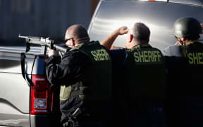 San Bernadino Sheriff officers pursue suspects of the shooting at the Inland Regional Center on 2 December 2015 in San Bernardino, California.