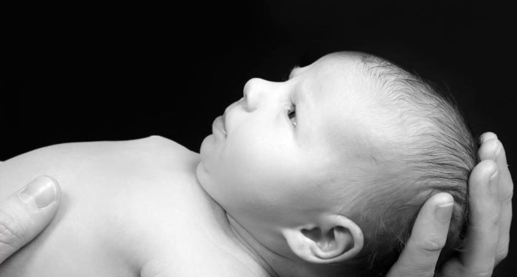 Newborn held in mother's hands