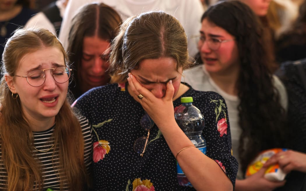 Mourners react during the funeral of British-Israeli sisters Rina and Maya Dee at the Kfar Etzion settlement cemetery in the occupied West Bank, on April 9, 2023. - On April 7, two British-Israeli sisters were killed, and their mother seriously wounded in a West Bank shooting attack, and Israel's army said it had launched a manhunt for the perpetrators. (Photo by Menahem KAHANA / AFP)