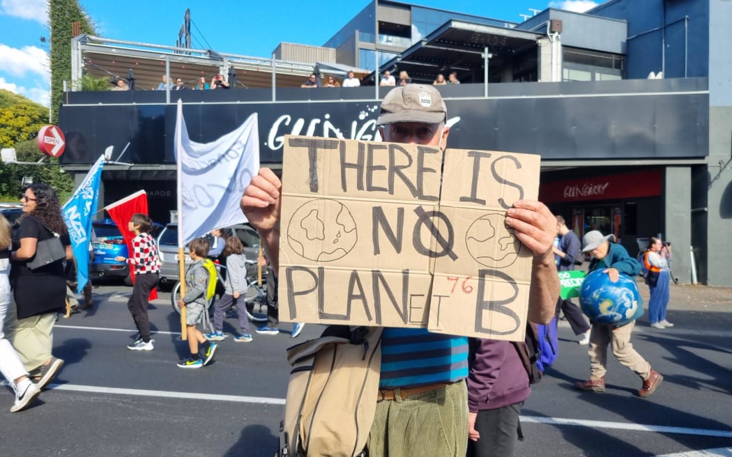 A protester with a "no planet b" placard at an Auckland climate protest on 26/5/2023