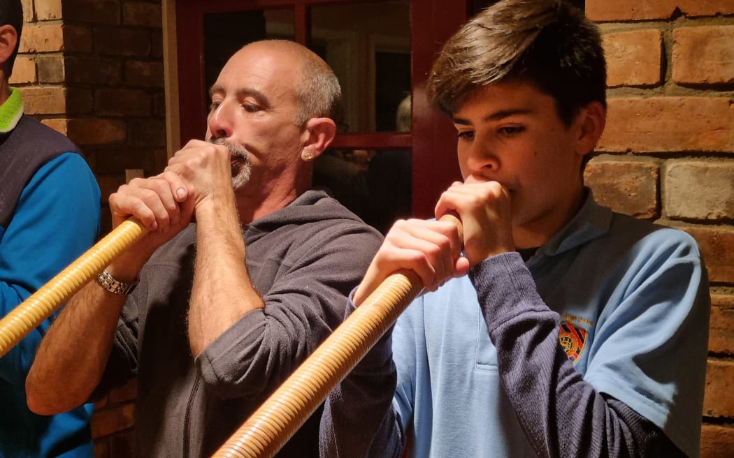 Aaron Boesch (left) plays the alphorn his father brought to New Zealand from Switzerland. Ryan Bühler (right), 15, is the youngest of the Taranaki Swiss Club's alphorn players.