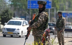 Indian paramilitary troopers stand guard along a street in Srinagar on April 30, 2025.