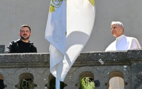 Ukraine's President Volodymyr Zelensky (L) and Pope Leo XIV stand on a balcony as they meet at the papal residence of Castel Gandolfo, southeast of Rome on July 9, 2025. (Photo by Andreas SOLARO / AFP)