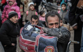 Civilians wait to be evacuated from Syria's eastern Al-Ghouta province outside Damascus.