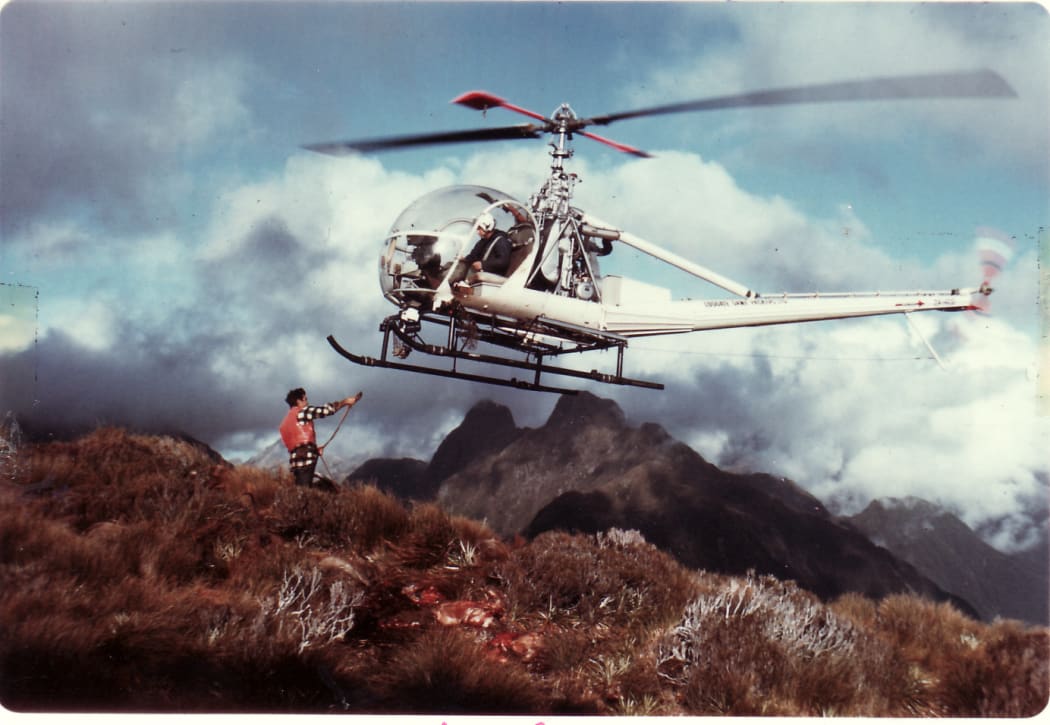 Man waiting to attach strop to helicopter in air