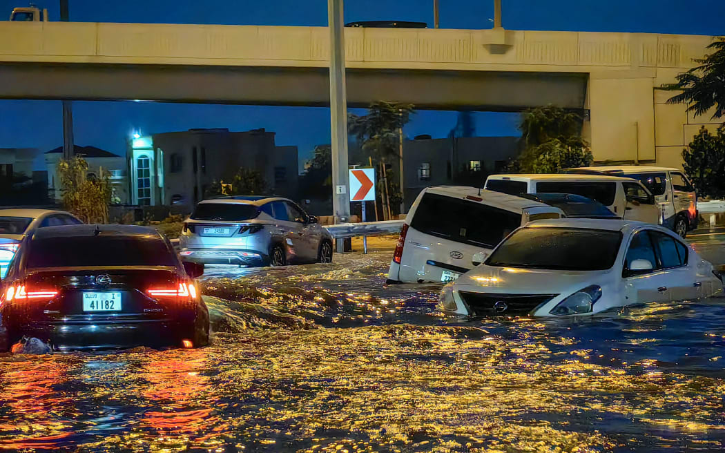 سيارات تسير في شارع غمرته المياه بعد هطول أمطار غزيرة في دبي في 17 أبريل 2024.  وأصيبت دبي المركز المالي في الشرق الأوسط بالشلل بسبب الفيضانات في أنحاء الإمارات العربية المتحدة والبحرين وفي 14 أبريل نيسان في عمان حيث لقي 18 شخصا حتفهم.  15. (تصوير جوزيبي كاكاس / وكالة فرانس برس)