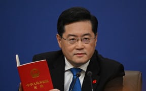 (FILES) (FILES) China's Foreign Minister Qin Gang holds a copy of China's constitution during a press conference at the Media Center of the National People's Congress (NPC) in Beijing on March 7, 2023. Qin Gang has been formally removed from the ruling Communist Party's highest decision-making body, state media reported on July 18, 2024, as a key political meeting concluded in Beijing. (Photo by NOEL CELIS / AFP)