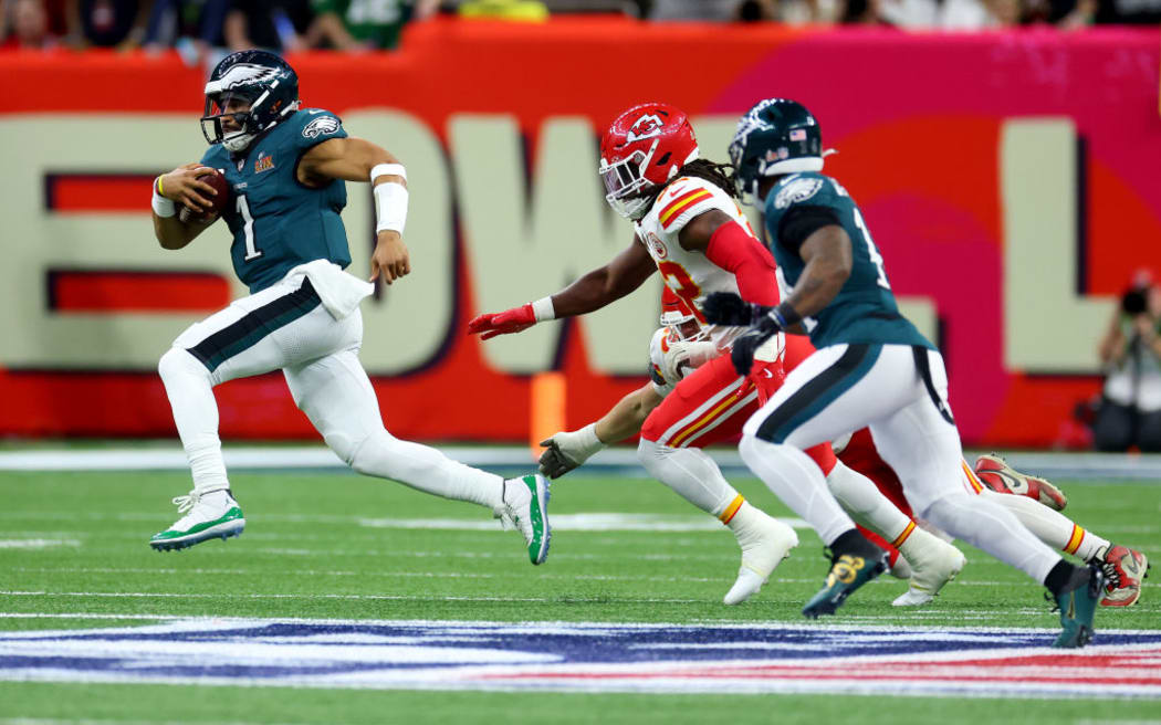 Jalen Hurts #1 of the Philadelphia Eagles runs with the ball while being chased by Nick Bolton #32 of the Kansas City Chiefs.