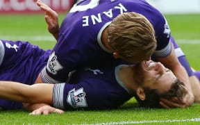 Tottenham Hotspur striker Harry Kane (up) attends to midfielder Ryan Mason, as he lies injured after scoring AFP PHOTO / IAN MACNICOL