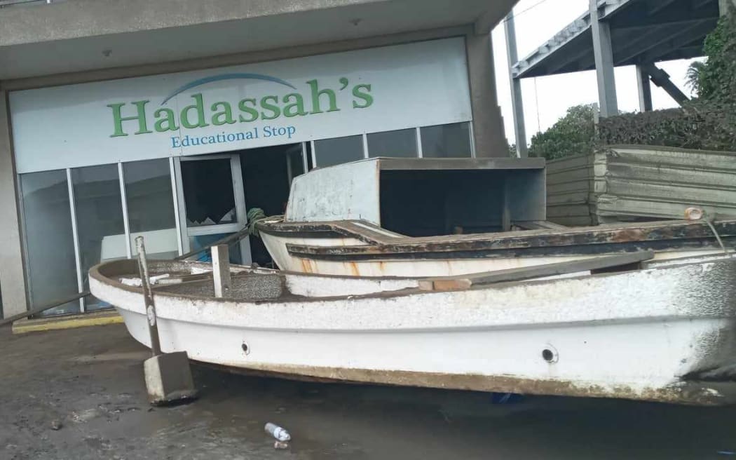 A fishing boat ends up on the road in front of this bookshop in Ma'ufanga, Tongatapu on 16 January 2022.