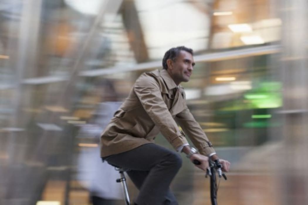 Corporate businessman riding bicycle. (Photo by CAIA IMAGE / SCIENCE PHOTO LIBRA / NEW / Science Photo Library via AFP)
