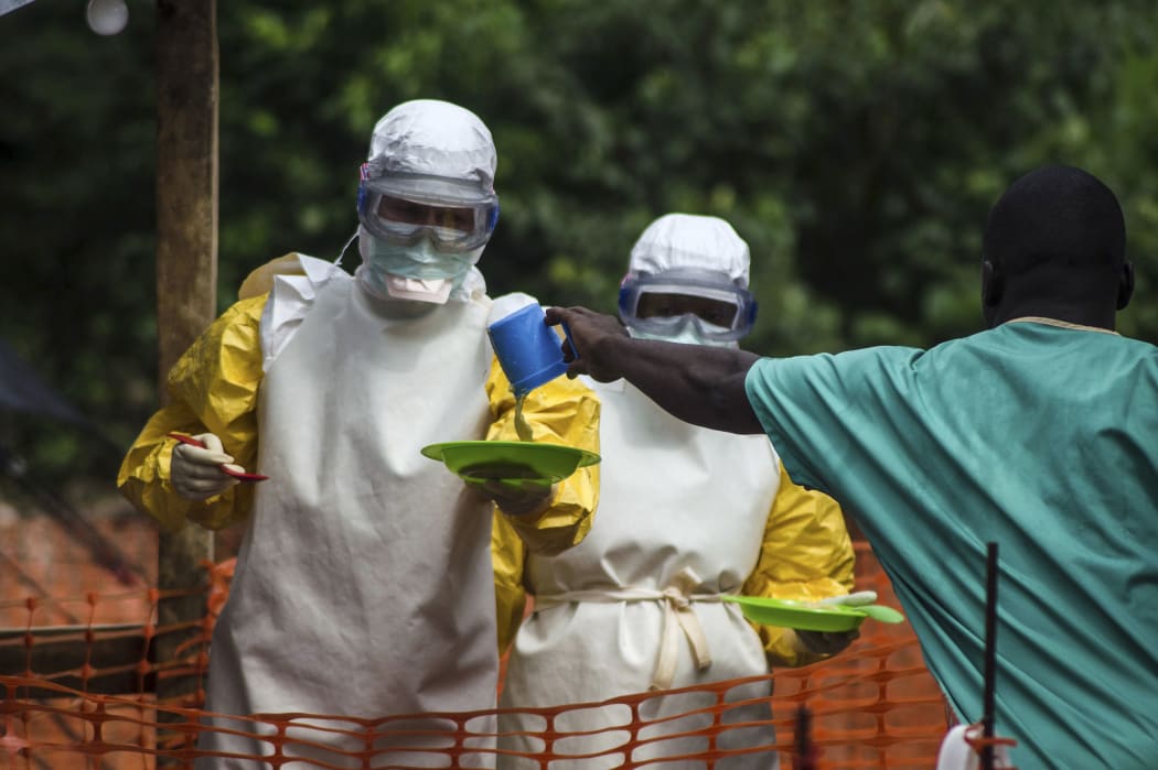 Medical staff working with Medecins sans Frontieres (MSF) prepare to bring food to Ebola patients in an isolation area.