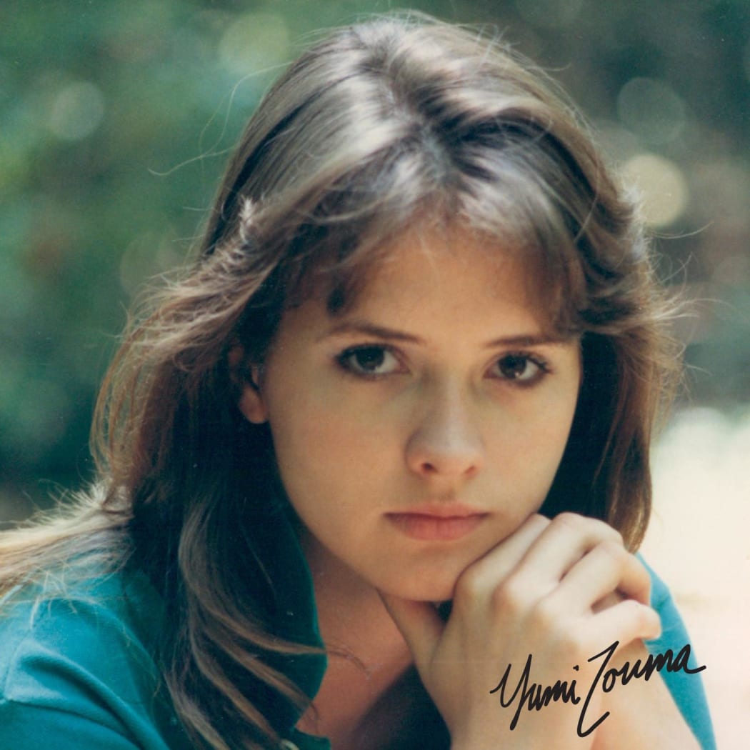Yumi Zouma EP cover- Brunette young woman with great bangs, in 80s style, turquoise polo neck, in thoughtful pose.