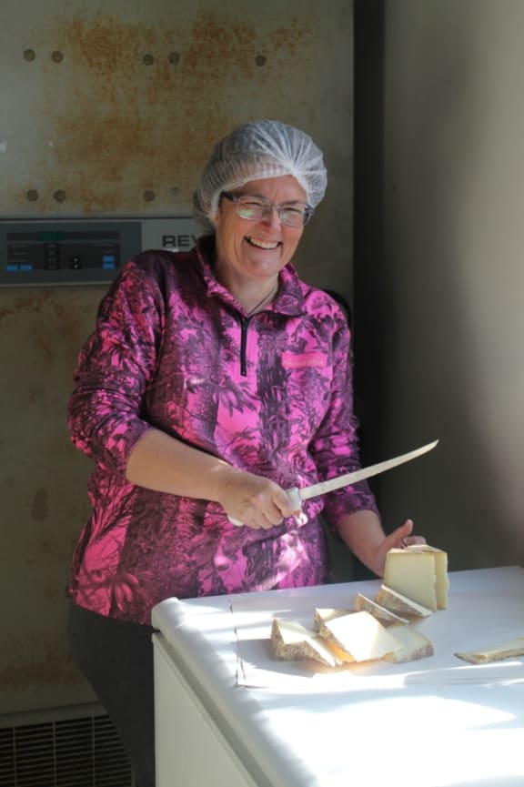 An image of cheesemaker Jo preparing cheese for market day.