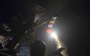 In this image released by the US Navy, the USS Ross fires a Tomahawk missile at a Syrian air force airfield (7 April 2017).