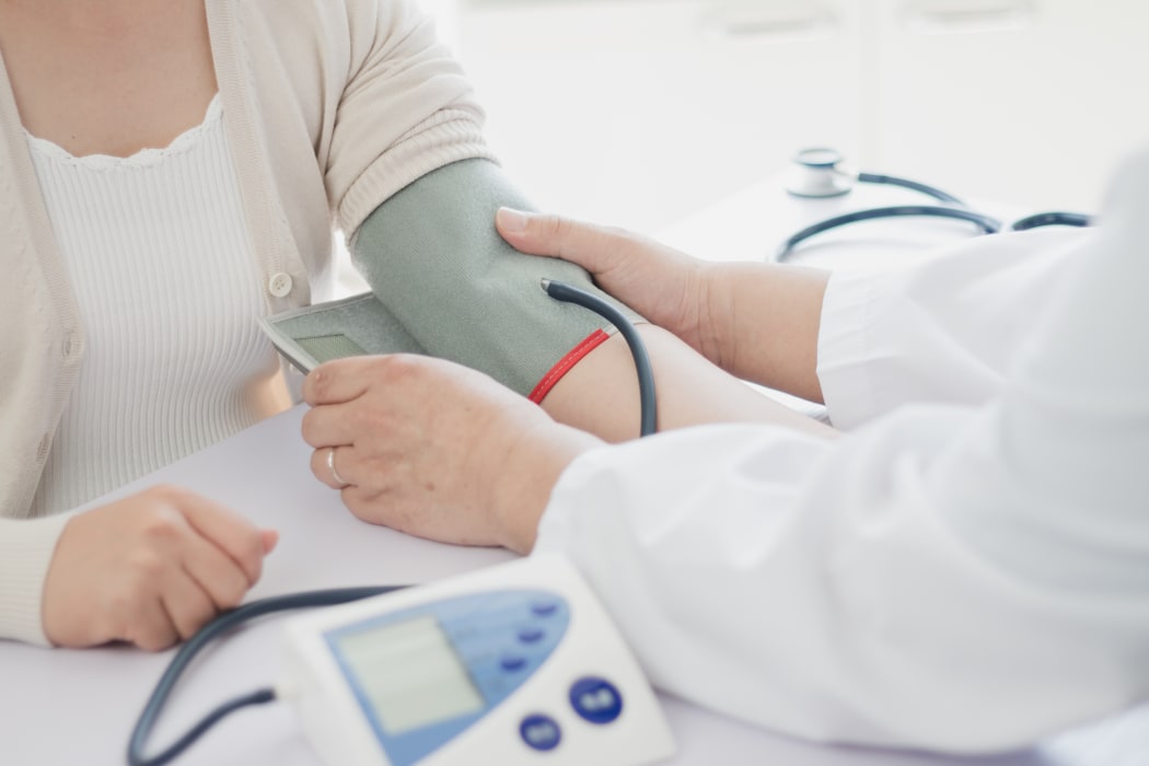 Doctor measures blood pressure of patient.