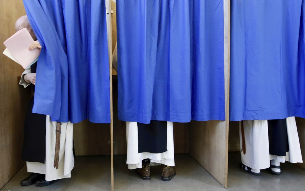 Monks from the Saint Sixtus Trappist Abbey cast their votes behind curtains at a polling station in Westvleteren, Belgium, Sunday, May 26, 2019.