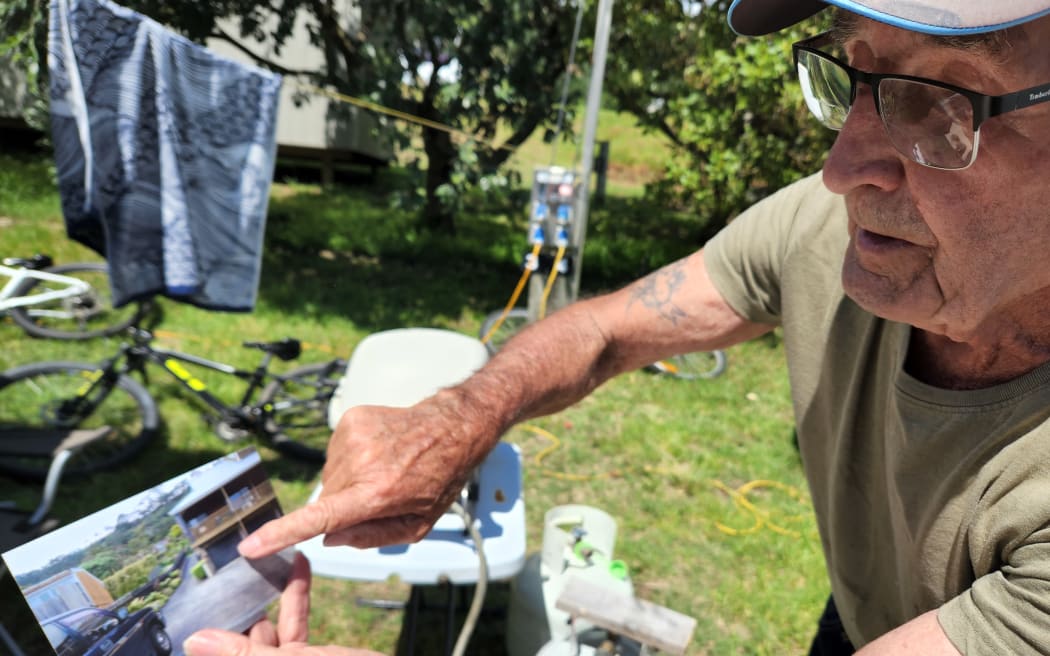 Carpenter Siegfried Walczak, 88, and his wife were evacuated from their home of 50 years the morning after the cyclone brought down a slip nearby. Siegfried Walczak is pointing to a photo of the home he built on Motutara Road in 1973.