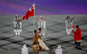 Malia Paseka and Pita Taufatofua carry the Tongan flag during the Tokyo 2020 Olympics Opening Ceremony.