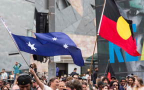 Protestors wave the Australian Flag with the Union Jack cut out and an Aboriginal Flag, during a protest, organized by Aboriginal rights activists on Australia Day in Melbourne,