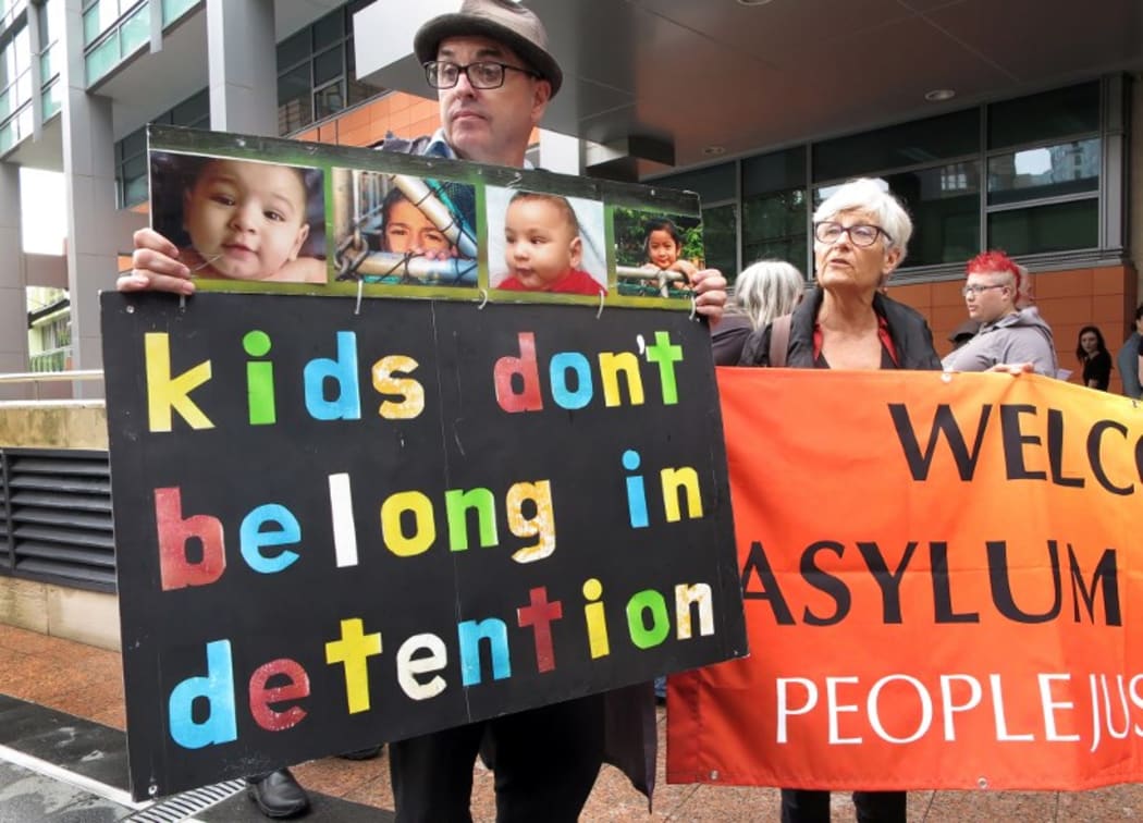 People hold placards at a protest outside an immigration office in Sydney in 2016.