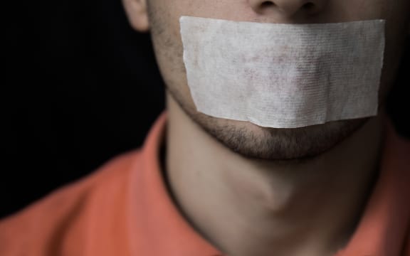 Man is silenced with adhesive tape on his mouth.