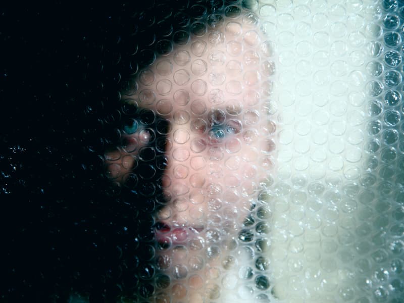 A man's face is made blurry by bubble wrap.