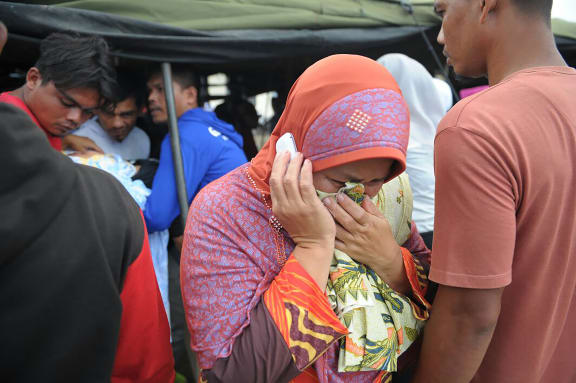 A woman grieves for her relative who died after an earthquake in Pidie Jaya, Aceh province on 7 December, 2016.