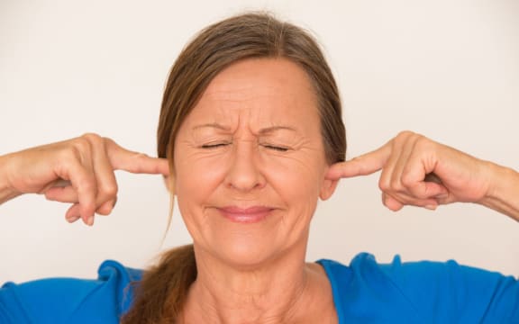 woman blocking her ears