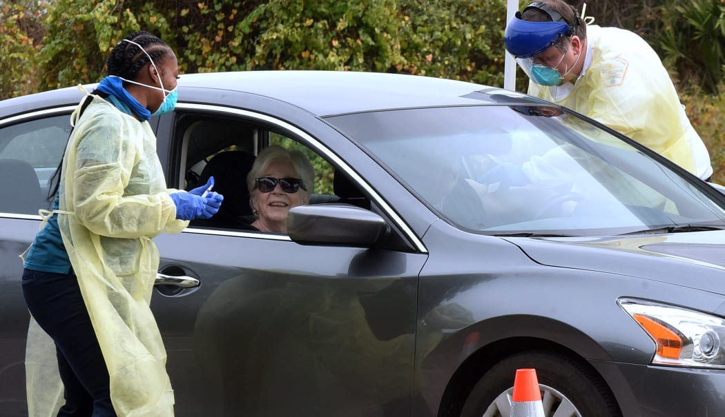 Health workers administer the Moderna COVID-19 vaccine to a couple in a car at a drive-thru vaccination event for residents 65 and older at Dewey O. Boster Park and Sports Complex on January 7, 2021 in Deltona, Florida.