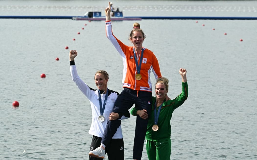Netherlands' gold medallist Karolien Florijn (TOP), New Zealand's silver medallist Emma Twigg (L) and Lithuania's bronze medallist Viktorija Senkute celebrate on the podium during the medal ceremony after the women's single sculls final rowing competition at Vaires-sur-Marne Nautical Centre in Vaires-sur-Marne during the Paris 2024 Olympic Games on August 3, 2024. (Photo by Bertrand GUAY / AFP)