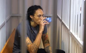 US Women's National Basketball Association (WNBA) basketball player Brittney Griner, who was detained at Moscow's Sheremetyevo airport and later charged with illegal possession of cannabis, drinks inside a defendants' cage during a hearing in Khimki outside Moscow, on August 4, 2022. - A Russian court found Griner guilty of smuggling and storing narcotics after prosecutors requested a sentence of nine and a half years in jail for the athlete. (Photo by EVGENIA NOVOZHENINA / POOL / AFP)