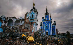 Construction workers climb onto the roof of a destroyed church in the village of Bohorodychne, Donetsk region on January 4, 2023, amid the Russian invasion of Ukraine. - Bohorodychne is a village in Donetsk region that came under heavy attack by Russian forces in June 2022, during the Russian invasion of Ukraine. On August 17, 2022 the Russian forces captured the village. The Armed Forces of Ukraine announced on September 12, 2022 that they took back the control over the village. A few resident came back to restore their destroyed houses and live in the village. (Photo by Dimitar DILKOFF / AFP)