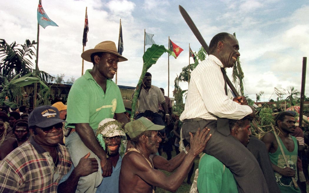 Sam Kauona (L), commander of the Bougainville Revolutionary Army (BRA), and Gerard Sinato (R), Premier of Bougainville, are carried on the shoulders of former guerillas during the signing ceremony for the Bougainville Cease-fire Agreement in Arawa on Bougainville 30 April 1998. The cease-fire officially ended a decade of brutal civil war which had claimed over 10,000 lives on the mineral-rich island.  AFP PHOTO/Torsten BLACKWOOD (Photo by TORSTEN BLACKWOOD / AFP)