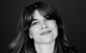 This is a black and white head shot of Jane Ward. She has shoulder length hair and is smiling at the camera.