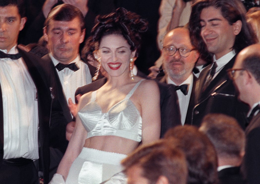 Madonna displays the outfit, designed by French Jean-Paul Gaultier as she leaves the Cannes Festival Palace after the screening of her movie "in Bed with Madonna", 13 May 1991 in Cannes.