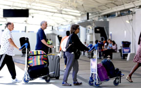 People queueing outside the international terminal at Auckland Airport as an external network outage causes major delays at the check-in counters on 11 December 2024.