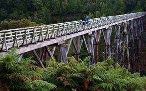 A pair of walkers cross the Percy Burn Viaduct on the South Coast Track near Tuatapere.