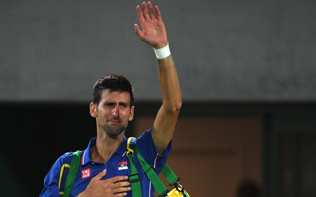 Serbia's Novak Djokovic waves to the crowd with tears in his eyes after losing his men's first round singles tennis match against Argentina's Juan Martin Del Potro at the Olympic Tennis Centre of the Rio 2016 Olympic Games in Rio de Janeiro on August 7, 2016.