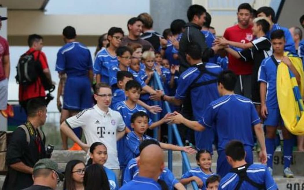 Guam players greet fans after training.