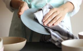 Housewife wipes the dishes with a towel. High quality photo