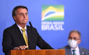 Brazilian President Jair Bolsonaro (L) speaks near Health Minister Marcelo Queiroga during the launching ceremony of a new registry of professional fishermen, at Planalto Palace in Brasilia on June 29, 2021.