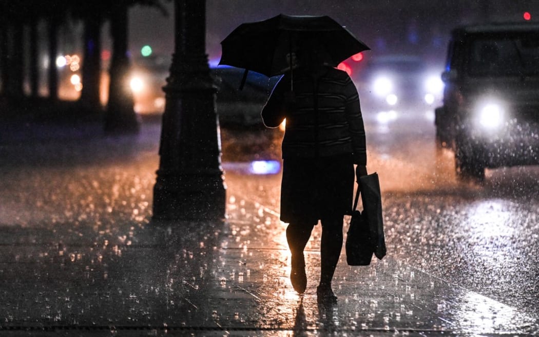 A man with umbrella walks along a street during a heavy rain, in downtown Moscow, Russia.